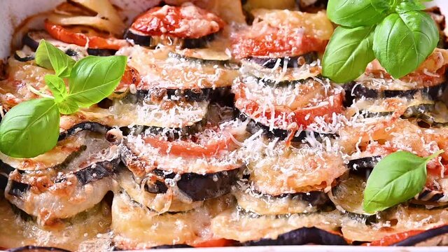 Traditional italian food. Baked eggplant, tomatoes with sauce, parmesan and basil. Rustic food for a healthy diet. Vegetables for lunch.	