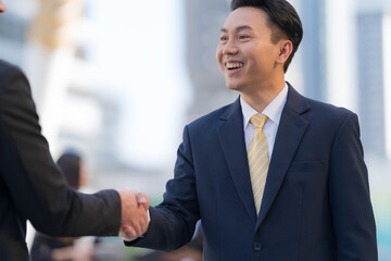 Close up, Handshake of two businessmen on the background of modern office, partnership concept
