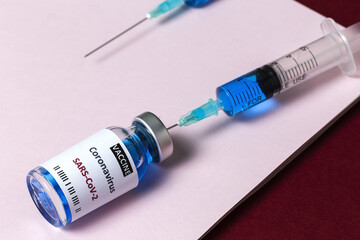 Transparent glass vials with test COVID-19 vaccine, with syringes