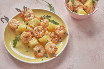 skewers of barbecued shrimp with a pineapple