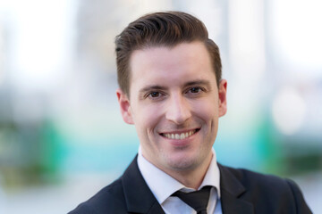 Fototapeta premium Close up of Smiling businessman standing in front of modern office