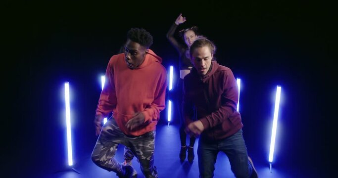 Studio, slow motion, a group of dancers jumping energetically 