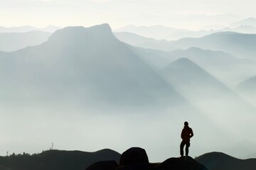 A young man stood looking at the mist surrounding the mountain ahead.