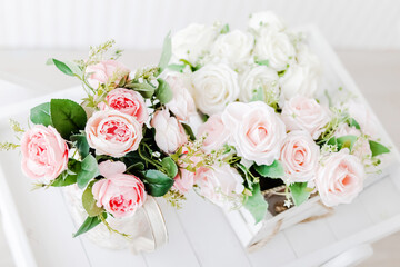 bouquet of artificial peonies and roses on a light wooden background