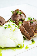 poached egg  with meat on a white plate