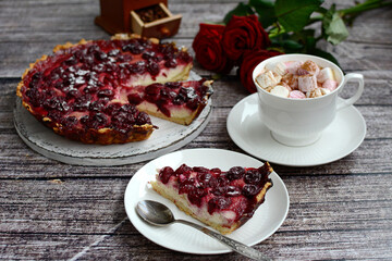 Composition of homemade cherry cheesecake, marshmallow coffee cups and a bouquet of roses on a wooden background