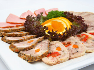 Meat assortment on white square ceramic plate