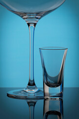 Wine glass and small glass on blue background