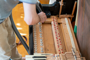 Setting up an old piano. The master repairs an old piano. Deep cleaning the piano. Hands of professional worker repairing and tuning an old piano. toned
