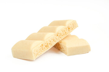 Two pieces of bubbly white milk chocolate isolated on white background