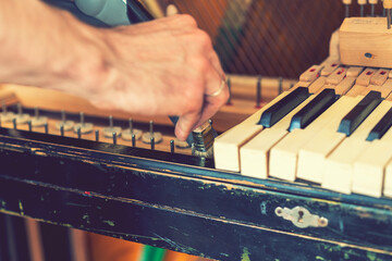 Setting up an old piano. The master repairs an old piano. Deep cleaning the piano. Hands of...