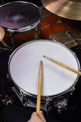 Professional drum set closeup. Man drummer with drumsticks playing drums and cymbals, on the live...