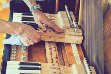 Setting up an old piano. The master repairs an old piano. Deep cleaning the piano. Hands of...