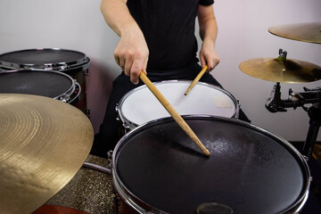 Professional drum set closeup. Man drummer with drumsticks playing drums and cymbals, on the live...
