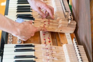Setting up an old piano. The master repairs an old piano. Deep cleaning the piano. Hands of professional worker repairing and tuning an old piano. toned © jollier_