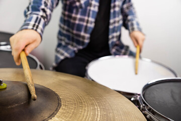 Professional drum set closeup. Man drummer with drumsticks playing drums and cymbals, on the live music rock concert or in recording studio   