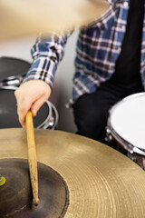 Professional drum set closeup. Man drummer with drumsticks playing drums and cymbals, on the live music rock concert or in recording studio   