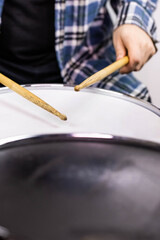 Professional drum set closeup. Man drummer with drumsticks playing drums and cymbals, on the live music rock concert or in recording studio   