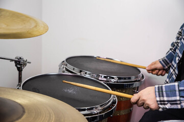 Professional drum set closeup. Man drummer with drumsticks playing drums and cymbals, on the live...