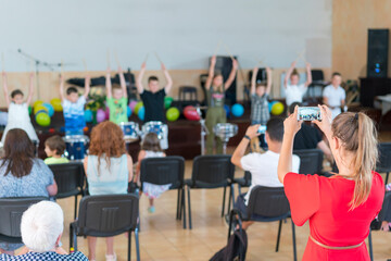 Children's holiday in elementary School. Children on stage perform in front of parents. image of blur kid 's show on stage at school , for background usage. Blurry. toned