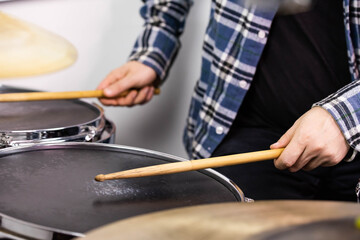 Professional drum set closeup. Man drummer with drumsticks playing drums and cymbals, on the live...