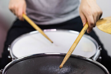 Professional drum set closeup. Man drummer with drumsticks playing drums and cymbals, on the live music rock concert or in recording studio   