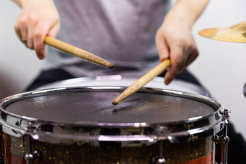 Professional drum set closeup. Man drummer with drumsticks playing drums and cymbals, on the live music rock concert or in recording studio   