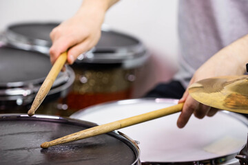 Professional drum set closeup. Man drummer with drumsticks playing drums and cymbals, on the live music rock concert or in recording studio   