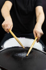 Professional drum set closeup. Man drummer with drumsticks playing drums and cymbals, on the live music rock concert or in recording studio   