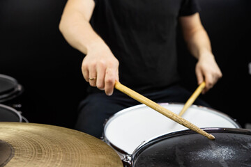 Professional drum set closeup. Man drummer with drumsticks playing drums and cymbals, on the live...