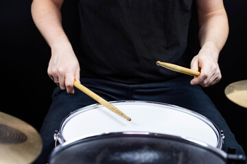 Professional drum set closeup. Man drummer with drumsticks playing drums and cymbals, on the live music rock concert or in recording studio   