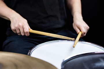 Professional drum set closeup. Man drummer with drumsticks playing drums and cymbals, on the live...