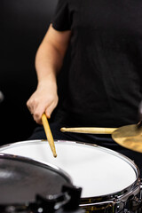 Professional drum set closeup. Man drummer with drumsticks playing drums and cymbals, on the live music rock concert or in recording studio   