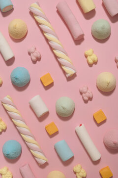 Candy pattern made of fluffy marshmallows and gummy bears. Pastel pink flat lay.