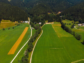 Aerial view over green meadow in Zgornje Jezersko, to Kamnik-Savinja Alps on a sunny summer day in Slovenia. Travel and tourism.