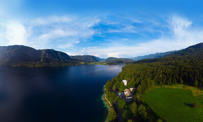 Fototapeta premium Aerial wide view of the Bohinj lake. Travel and tours concept. landscape ot the Triglav national park, summer forest and mountains. Copy space. on background Stara Fuzina. Slovenia, Europe