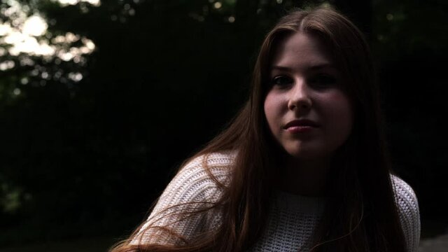 [4k] slow motion portrait of cute yount woman sitting outdoors ranting out of nothing before starting to laugh
