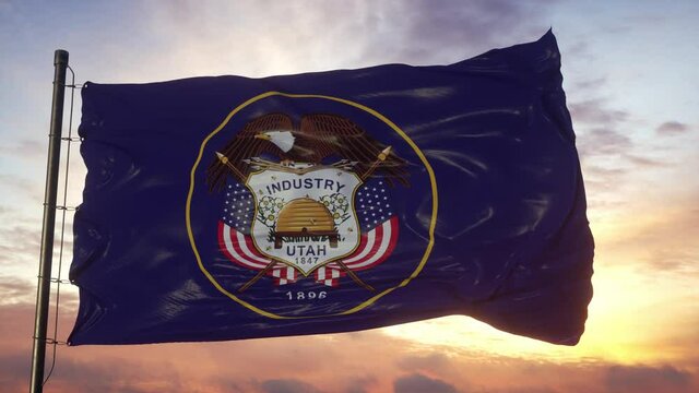 Flag of Utah waving in the wind against deep beautiful sky at sunset