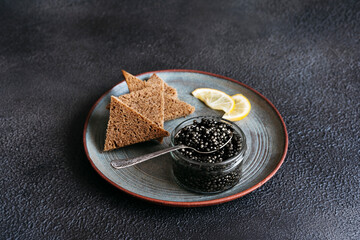 Black fish caviar with slices of black bread.