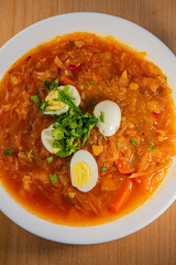 Ukrainian borscht in a plate with boiled chicken egg wedges.