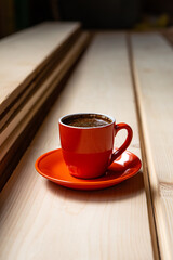 Cup of Coffee on a Plate in the Workroom Stands on Polished Pine Boards. Cover.