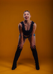 Beautiful sexy woman with braided black hair looking directly at the camera while being isolated on an orange background