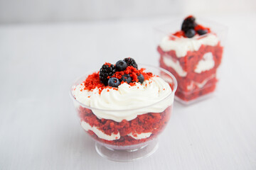 homemade portioned dessert red velvet decorated with berries on a light wooden background