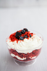 homemade portioned dessert red velvet decorated with berries on a light wooden background