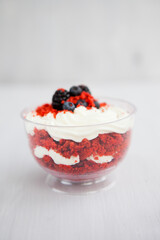 homemade portioned dessert red velvet decorated with berries on a light wooden background