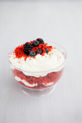 homemade portioned dessert red velvet decorated with berries on a light wooden background
