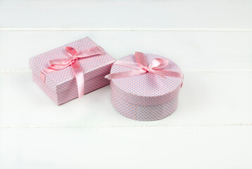 Two gift boxes with pink bow on white background
