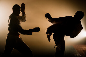 Two red and blue belt fighters training karate in gym