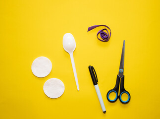 Making Easter bunny from plastic spoon and cotton pad on yellow background. Homemade easy children's craft. Simple creative art project.Step by step instructions.Decor for spring. DIY concept. Step 1