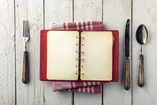Vintage Empty Cookbook on Wooden Table with Old Silverware